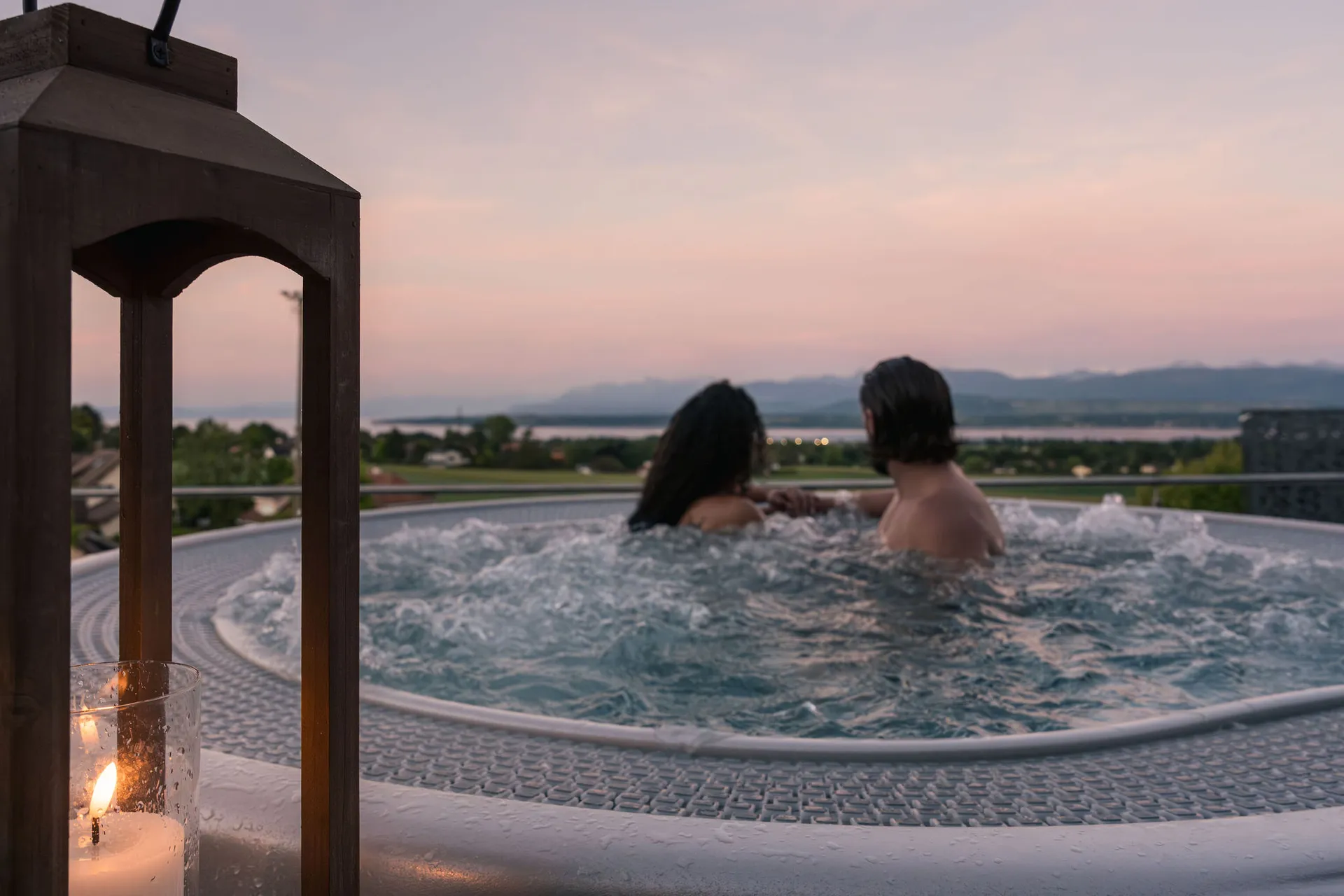 Couple dans le jacuzzi au coucher de soleil, lanterne