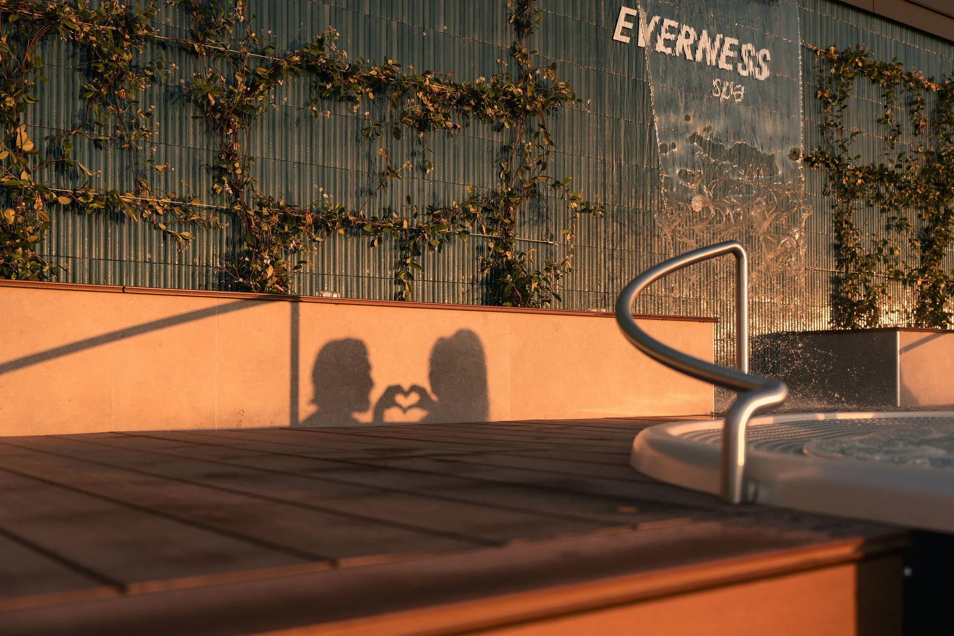 Coucher de soleil au Spa Everness — ombres d'un couple formant un cœur sur le mur